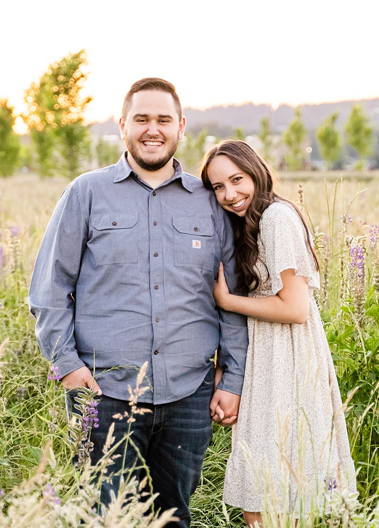 Man and Woman standing in a field at sunset