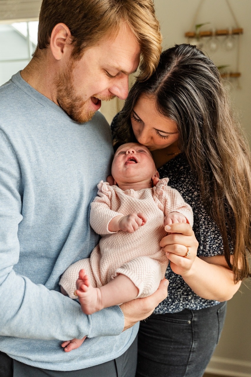 New Mom and Dad cuddling newborn baby